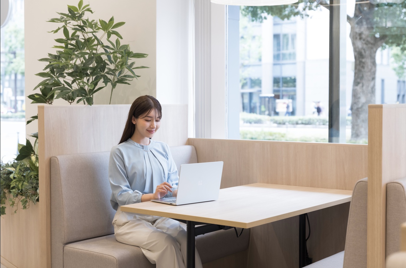ラウンジで仕事をしている様子。窓があり開放的なラウンジ