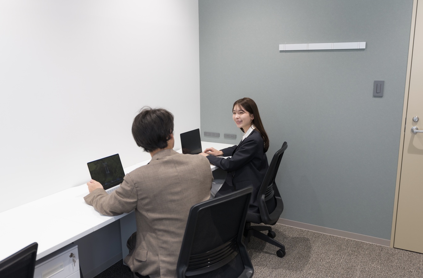 個室で男性と女性が仕事をしている様子。