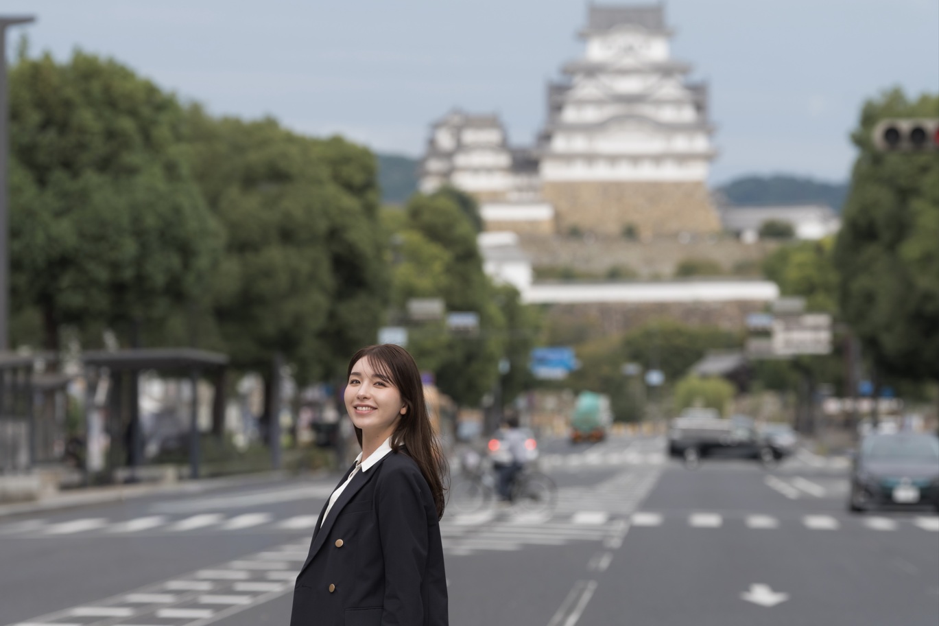 姫路城を背景に歩いている女性