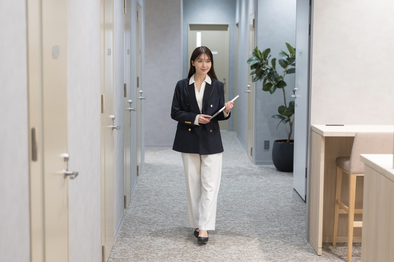 書類を片手に施設内を歩いている女性